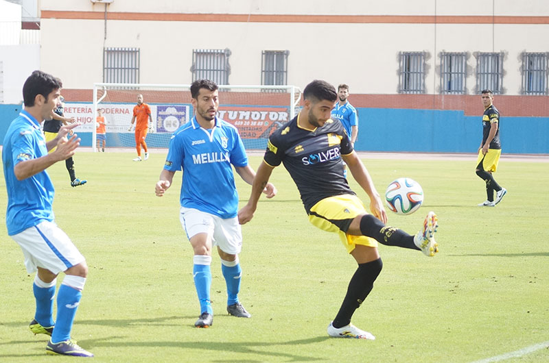 Jona controla un balón ante la mirada de dos jugadores de la UD Melilla / udmelilla.es