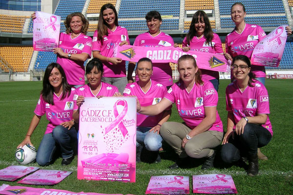 Trabajadoras del Cádiz CF con la camiseta rosa y la cartelería del Cádiz - Cacereño / cadizcf.com
